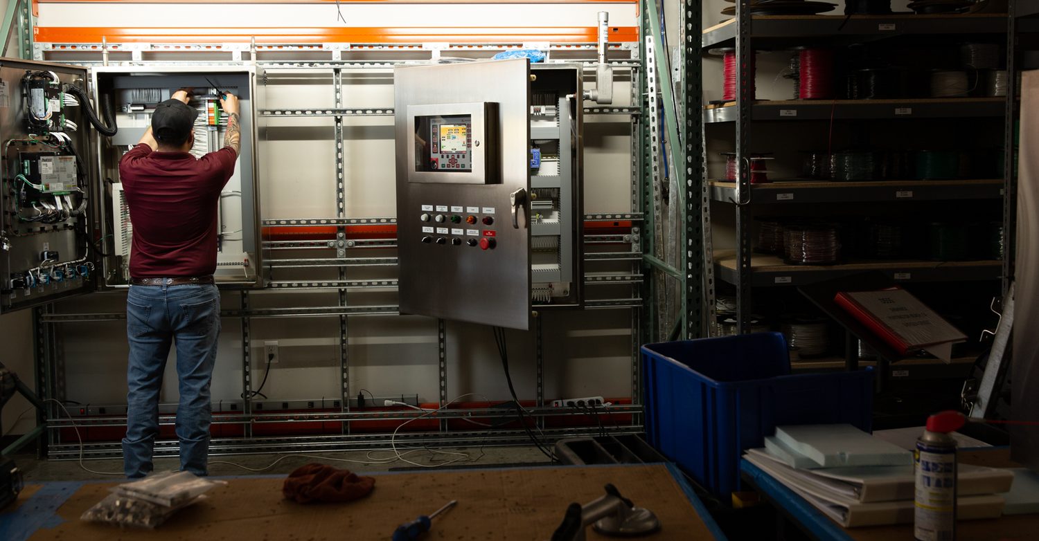 Drake Controls technician wiring an open operator control panel